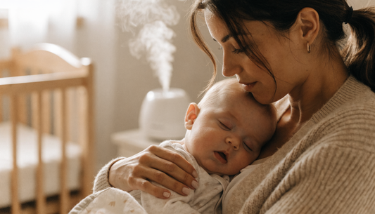 Moeder houdt haar verkouden baby tegen zich aan, met luchtbevochtiger op de achtergrond