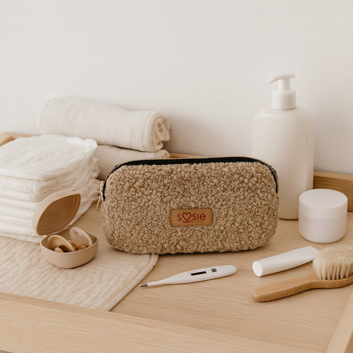 Soosie luieretui van teddy, beige, op de commode tussen babyverzorgingsspullen