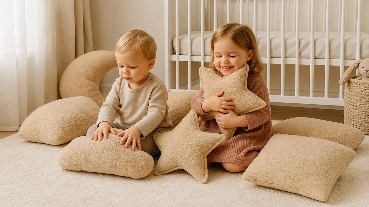 Twee kinderen spelen met teddy boucle sierkussens in een lichte babykamer