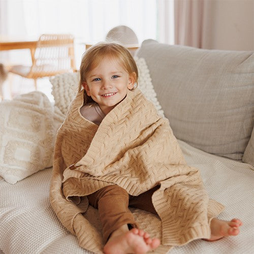 Kind gewikkeld in merino wollen babydeken Donkerbeige