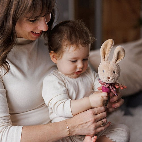 Moeder en baby spelen met de piepknuffel Rabbit Karo