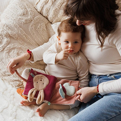 Baby speelt met het voelboekje Rabbit Karo